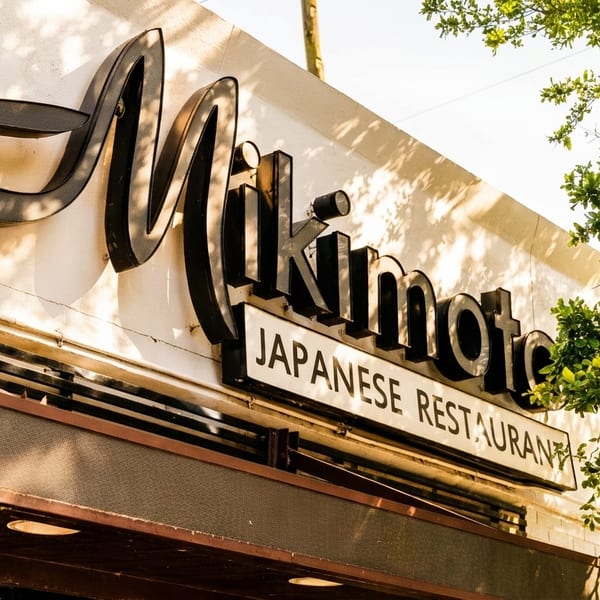 Exterior view of the Mikimoto Japanese Restaurant sign on a sunny day.
