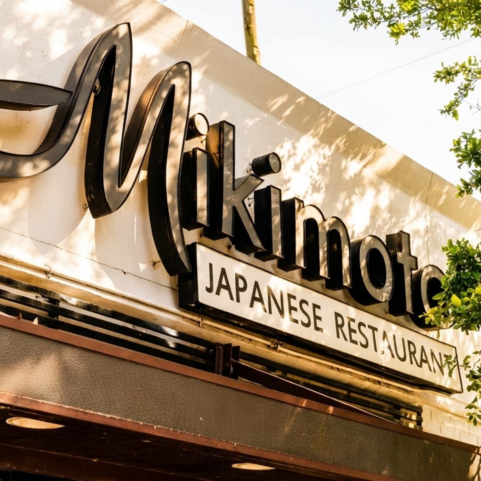 Exterior view of the Mikimoto Japanese Restaurant sign on a sunny day.